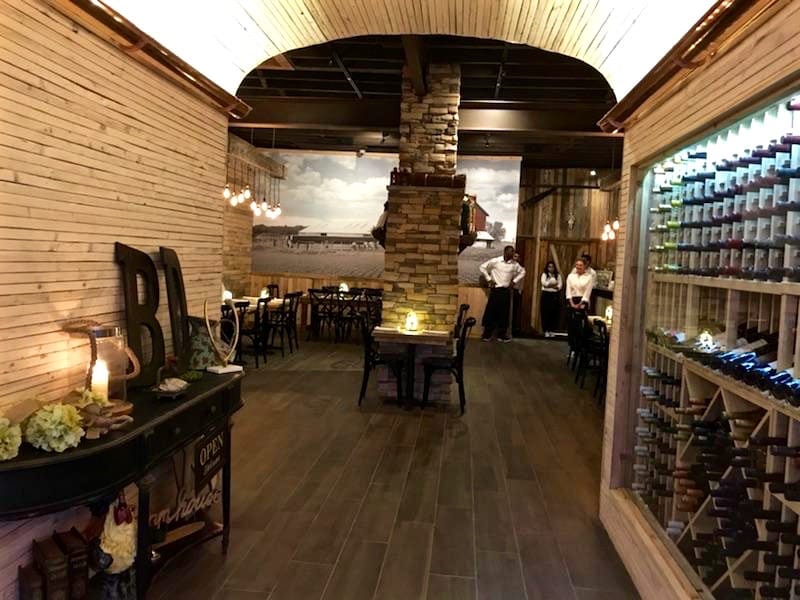 The extended archway to the dining room offers diners a glimpse of wine options.