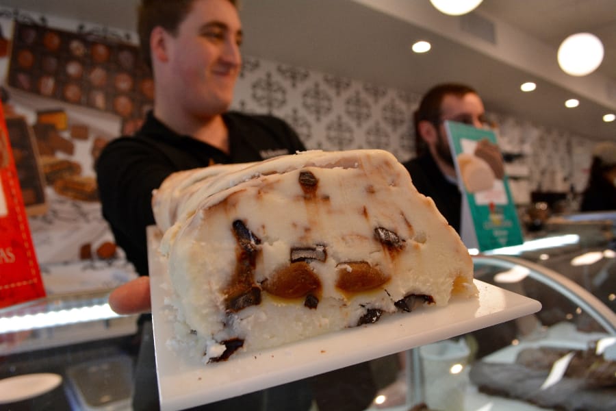 Manager Pat Delaney holds up a log of Kilwins Mud fudge, which consists of vanilla, chocolate chip and caramel.