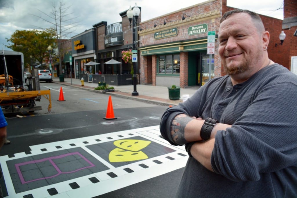 Artist Dave Rogers watches over the crosswalk installation Wednesday. (Michael White)