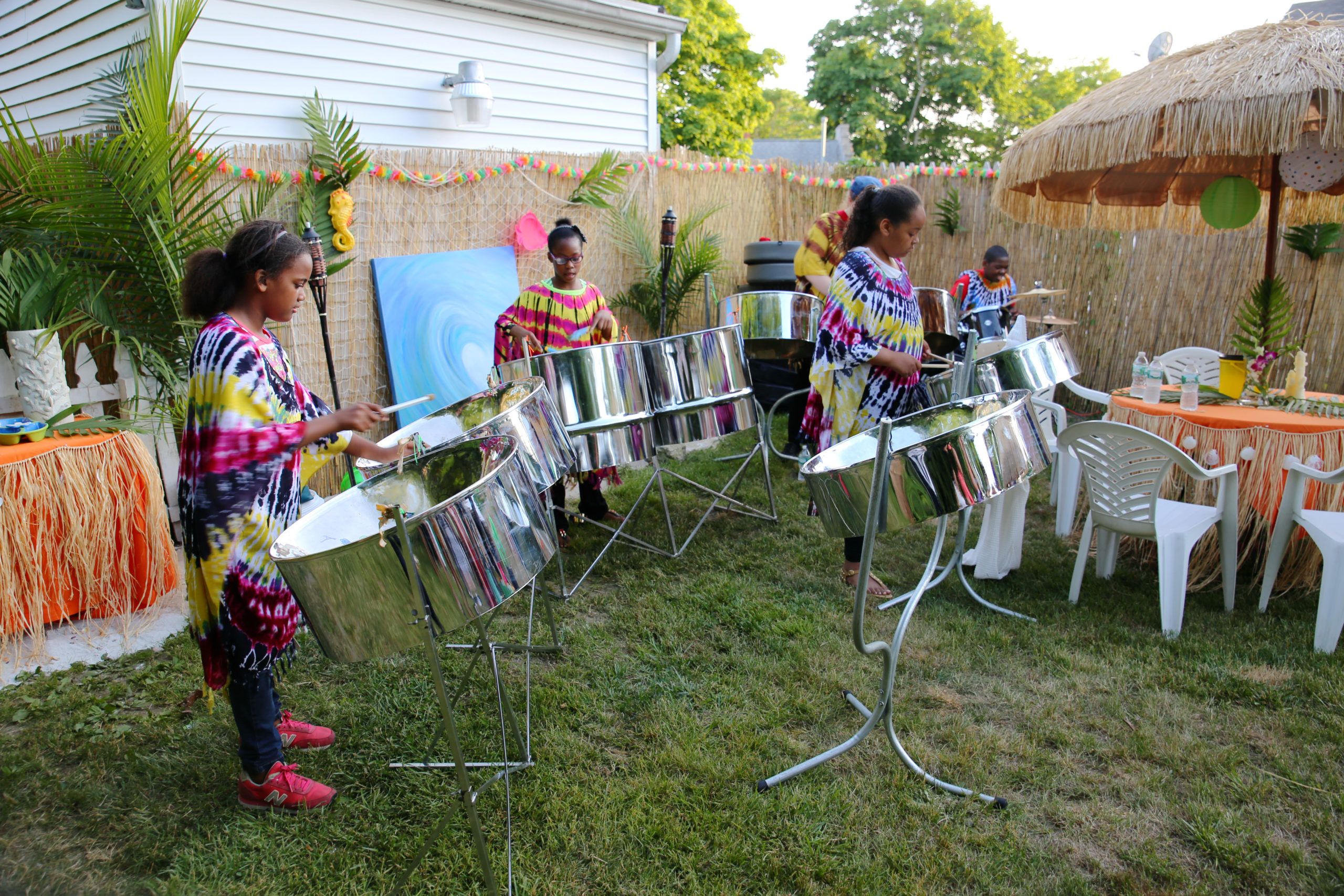 Four members of the steel drum band perform at a June 12 grand opening event in Bellport Village. (Credit: Ming Photography)