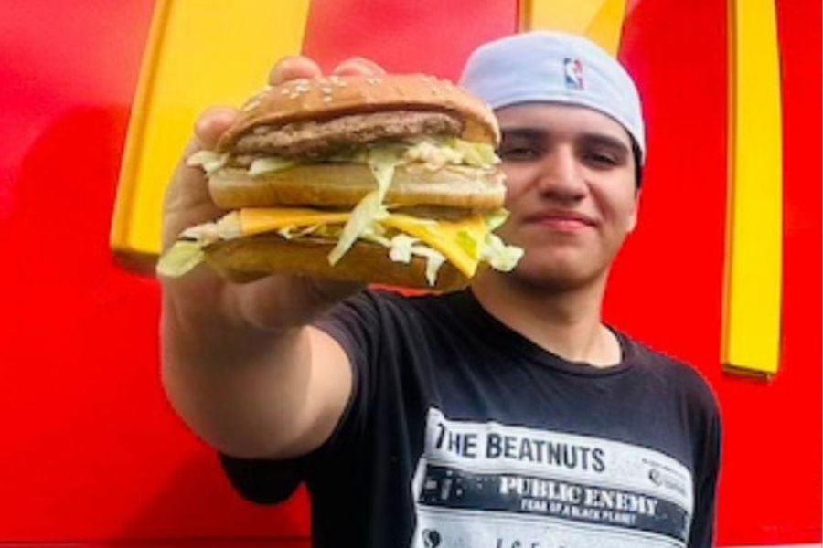 Mikey Grasing, a rising junior at Miller Place High School, holds up a Big Mac outside a McDonald’s.