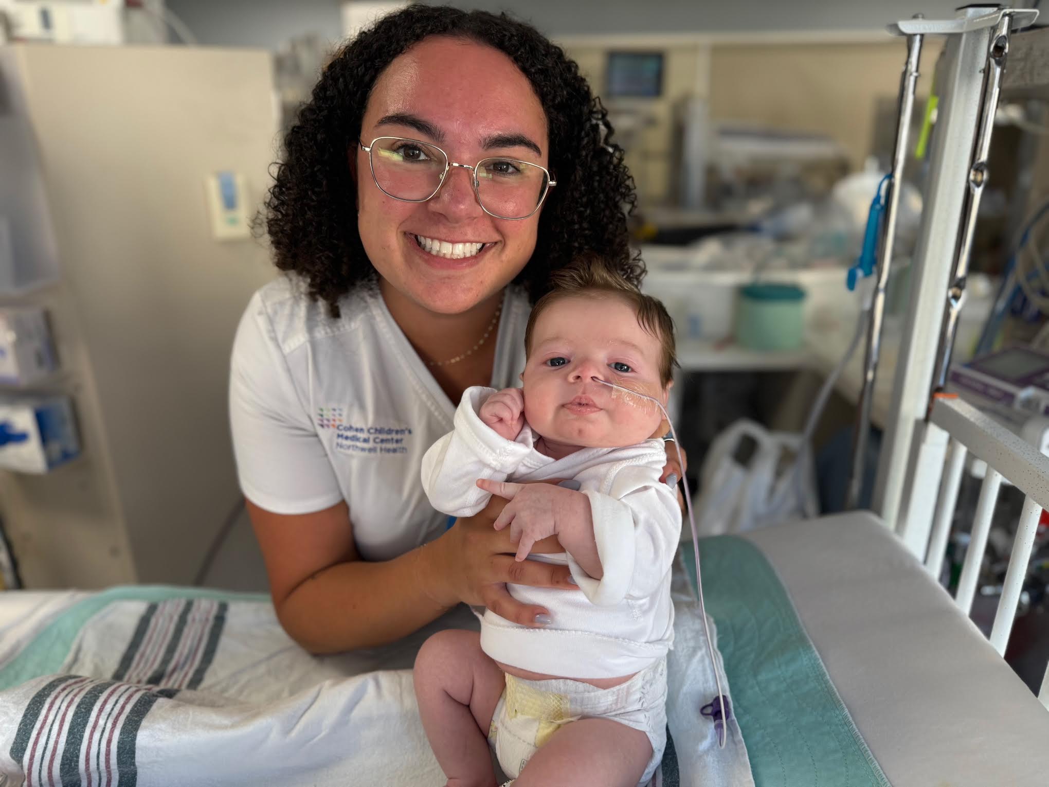 A child patient at Cohen Children’s Medical Center interacts with a hospital worker, highlighting compassionate pediatric care at the New Hyde Park facility.