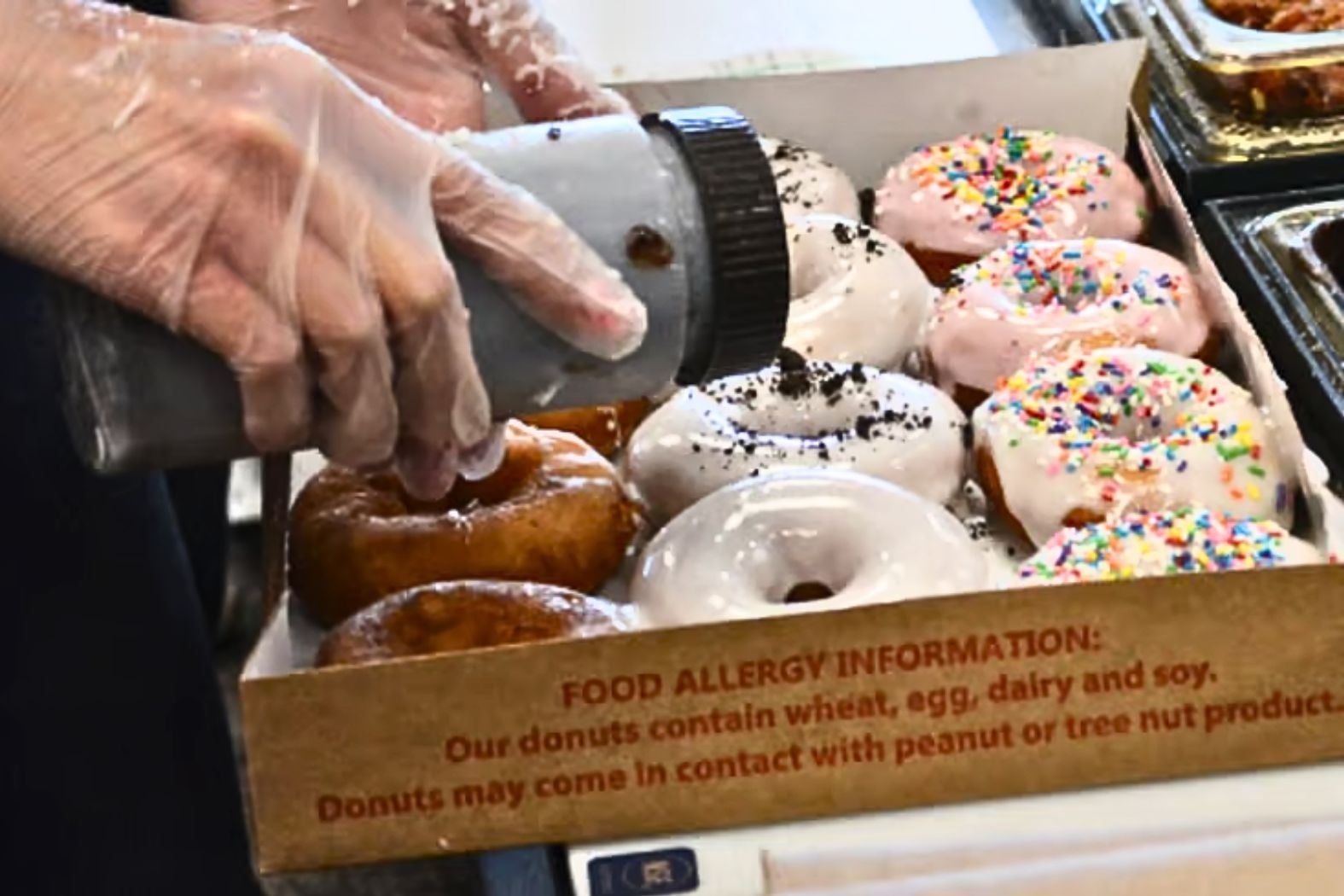 A worker puts the finishing touches on a box of Duck Donuts.