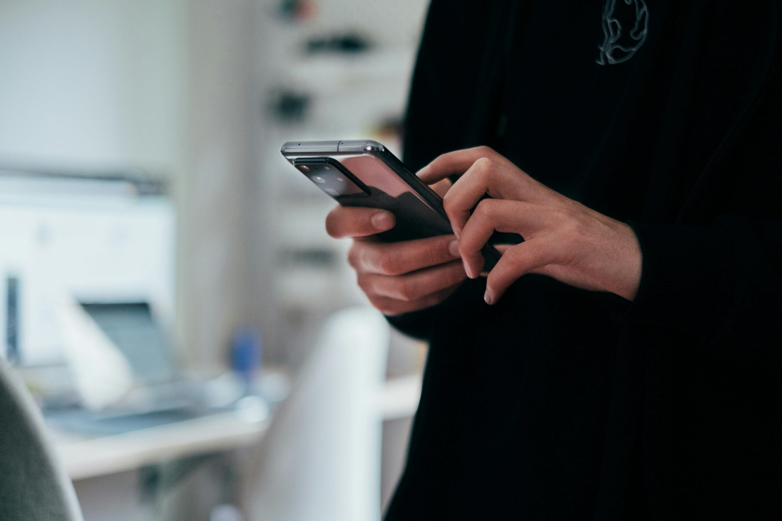 Man pressing buttons on phone in ominous setting