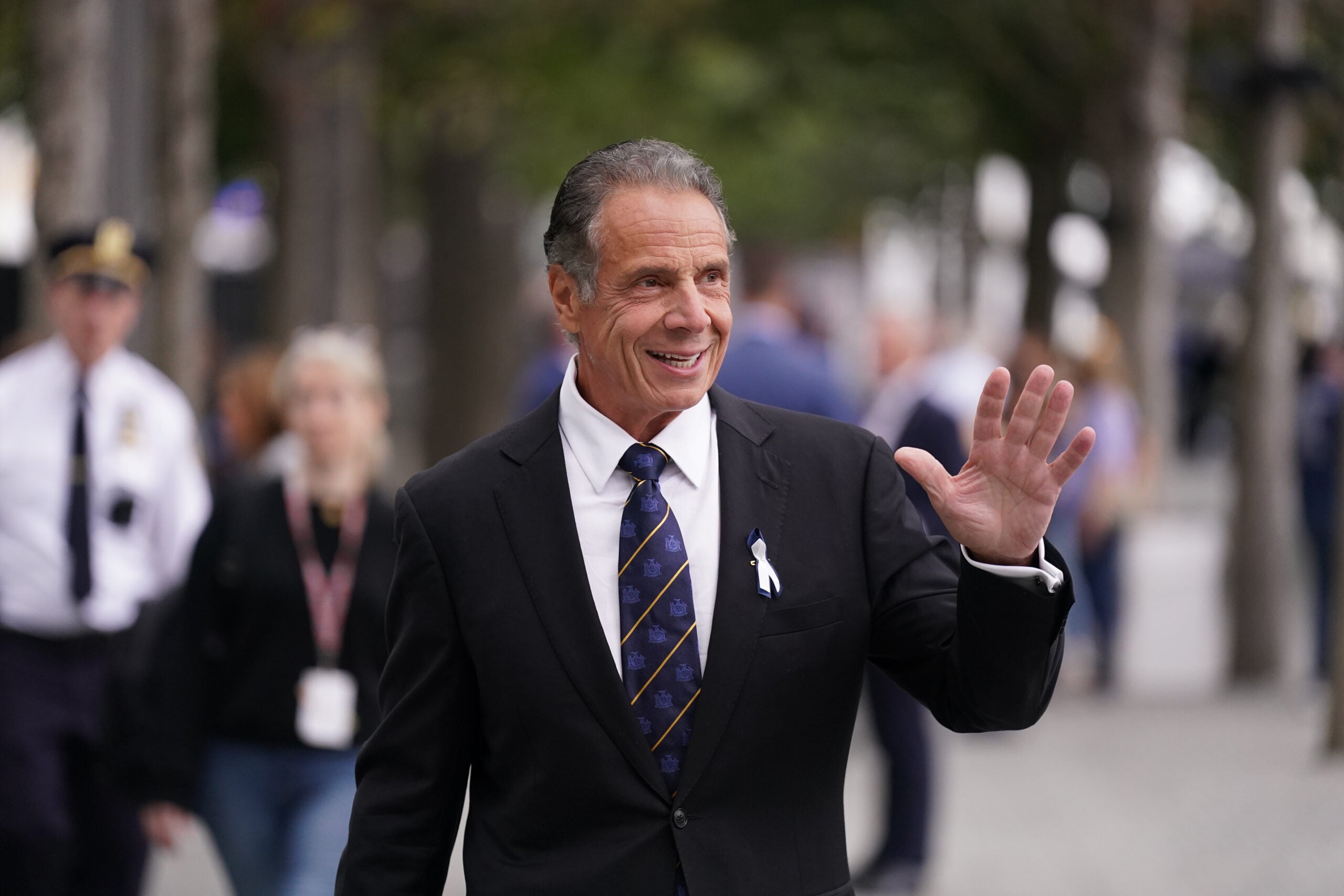 Andrew Cuomo walking, smiling and waving.