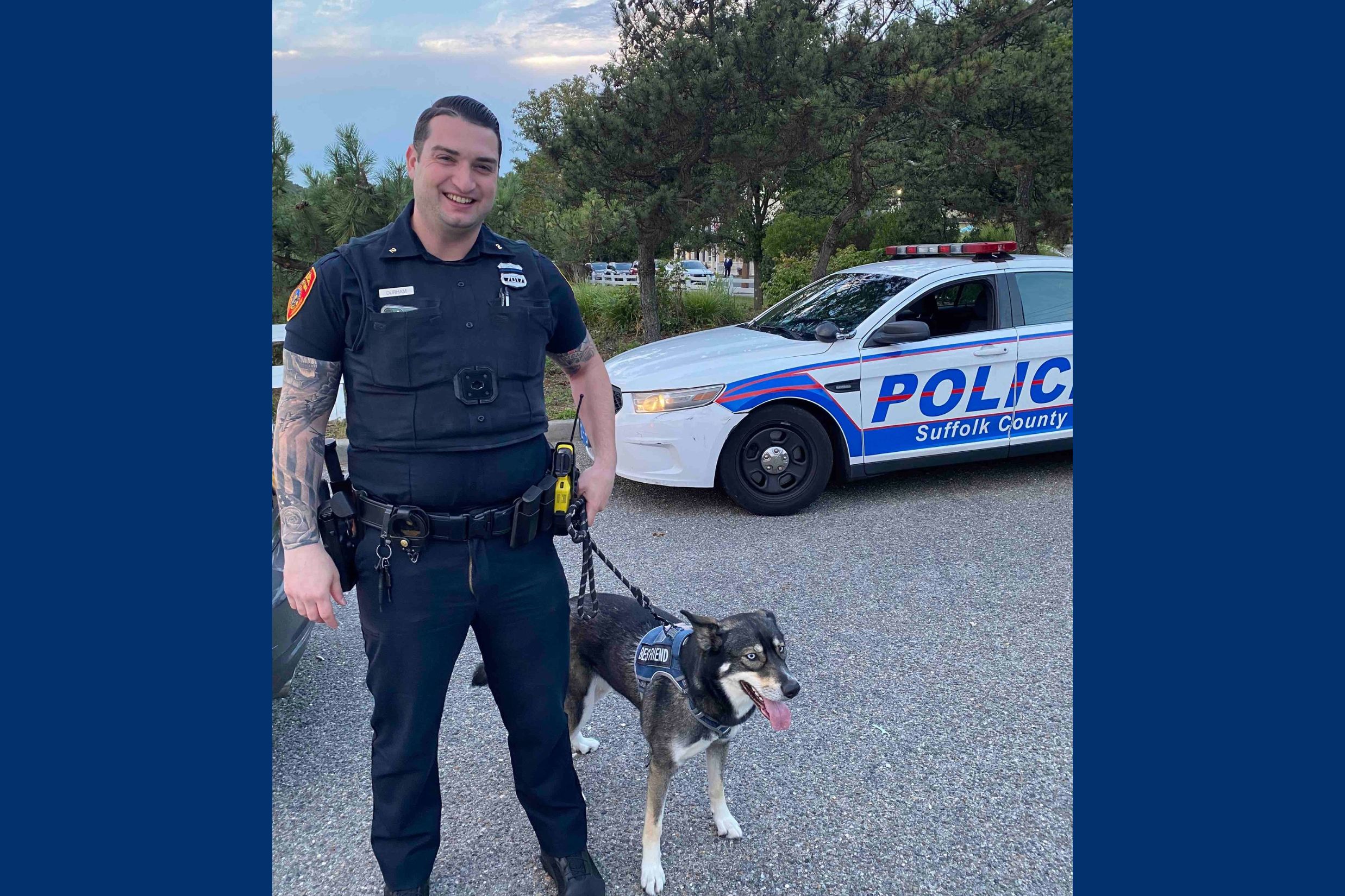 Officer Chris Durham with police dog in front of Suffolk Police car.