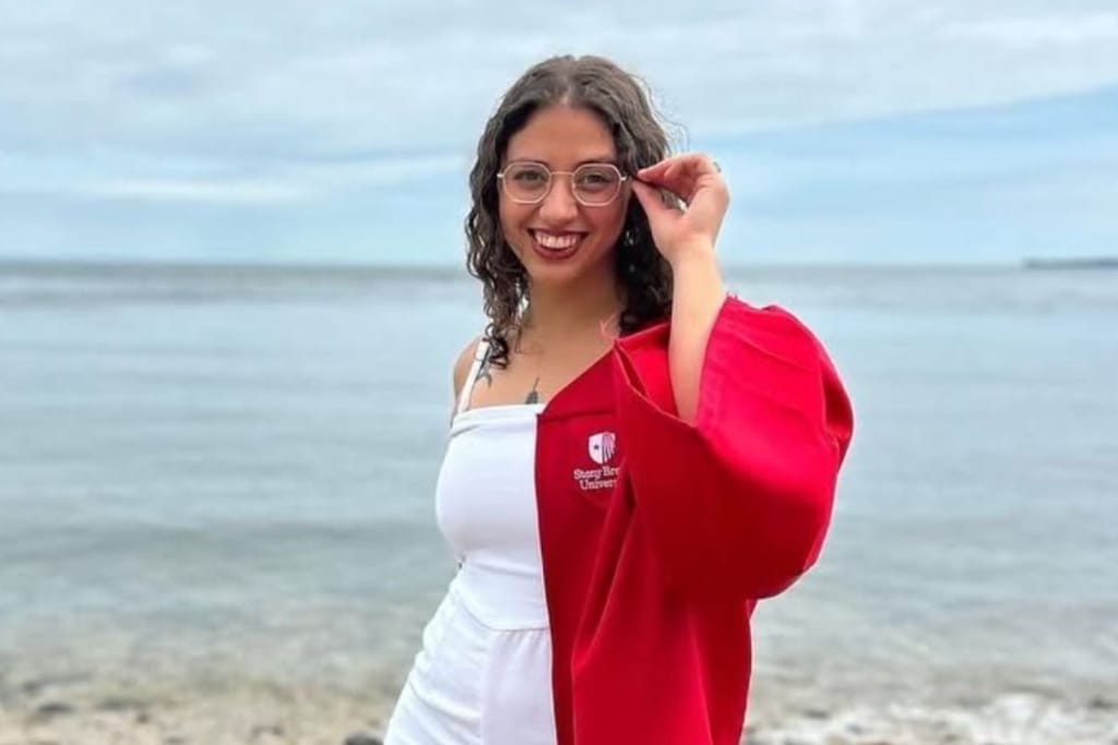 Victoria Castle in Stony Brook graduation gown on the beach.