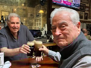 Top: Tom Forte (L) clinks Guinness pints with longtime Finnegan's regular John “Scotty” Fagan in Huntington. (Credit: Kevin Redding)