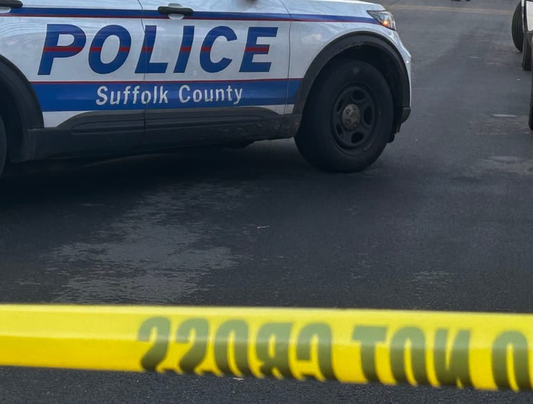 Police car and yellow crime scene tape at an accident scene.