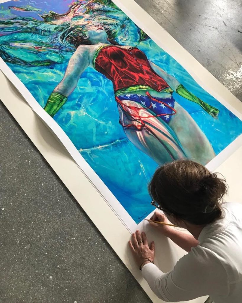 Artist Jennifer Hannaford signing one of her underwater paintings.