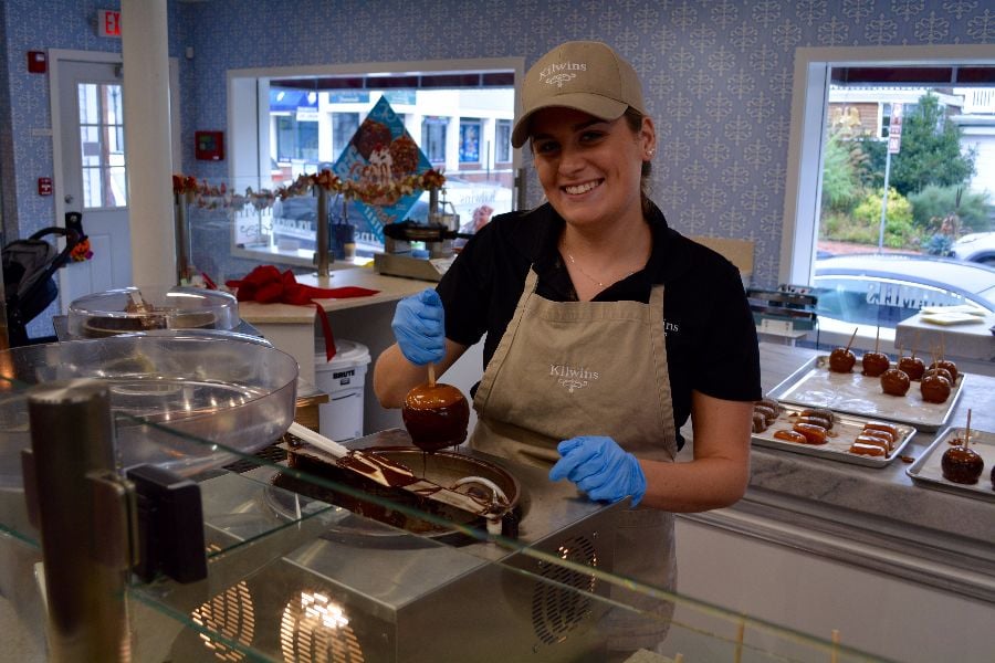 Anna Viscount dipping caramel apples in the kitchen Sunday morning at Kilwins Port Jefferson. (Michael White)
