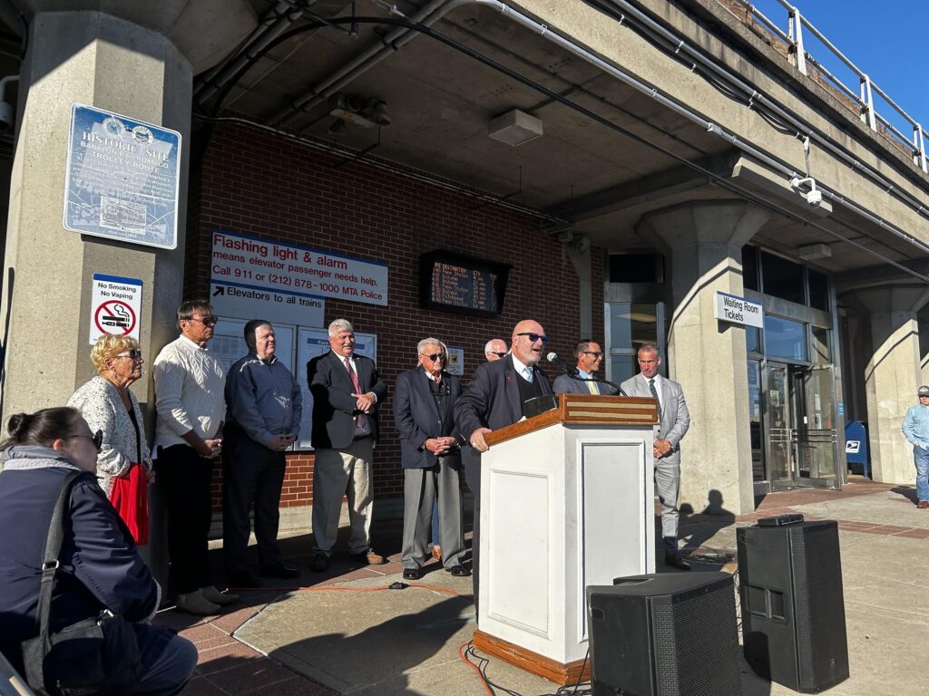 Babylon Village Trustee Dominic Bencivenga takes to the podium Sunday outside the Babylon LIRR station. (Credit: Michael Campbell)